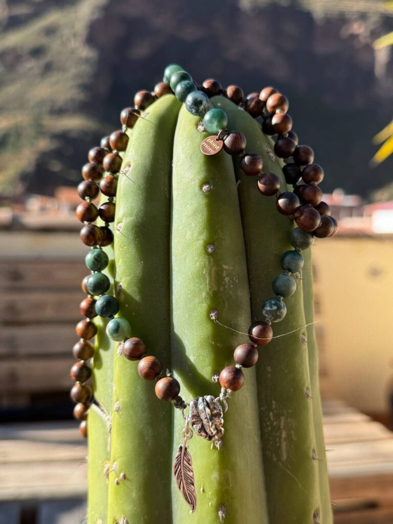 A strand of prayer beads hanging against a weathered stone column.